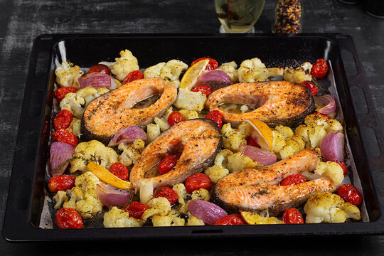 Sheet Pan Salmon and Vegetables on Dark Background. Overhead