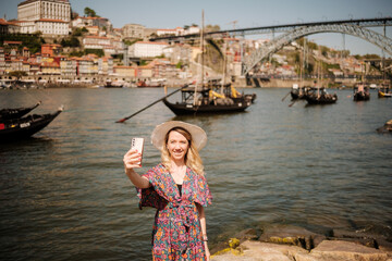 Fototapeta premium Woman taking selfie on douro riverfront in porto