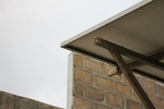 Rooftop solar panel mounting structure details photographed from low angle against bright sky background