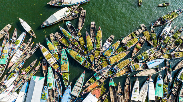 Rangamati, Bangladesh - 19 October 2022: Aerial view of numerous wooden boats laden with produce docked at the Rangamati floating market, with calm water and vibrant activity.