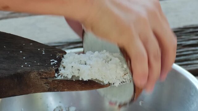 Traditional way, coconut grater and grate coconut into container,coconut milk.