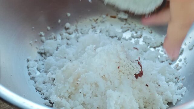Traditional way, coconut grater and grate coconut into container,coconut milk.