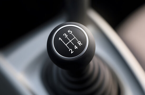 Top-down close-up shot of a 5-speed manual gear shift knob in modern car interior, representing automotive transmission, manual driving, mechanical control, and vehicle detailing.