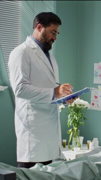 Doctor in white robe examines woman lying in bed in hospital