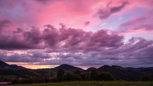 Sunset Timelapse Of Vibrant Pink And Purple Clouds Over Mountain Landscape
