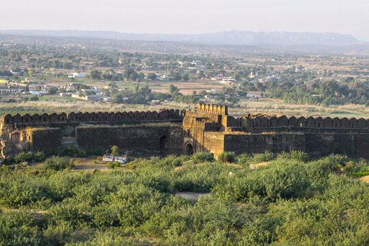 View of the historic Rohtas Fort with its massive stone walls and battlements set against a rural landscape in Dina, Punjab, Pakistan.
