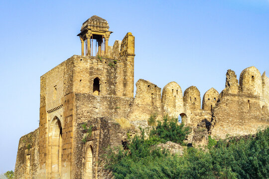 View of the historic stone walls and watchtower of Rohtas Fort under a clear blue sky in Dina, Punjab, Pakistan.