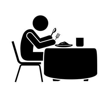 A black silhouette of a person sitting at a dining table eating a meal with a fork and spoon presented as isolated on transparent background