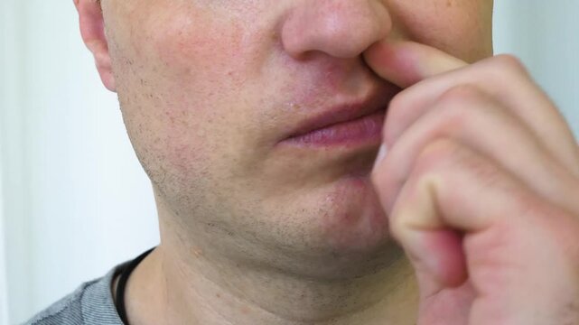 A man is picking his nose with his finger. To scratch your nose with your finger, pick your nose with your finger inside it.