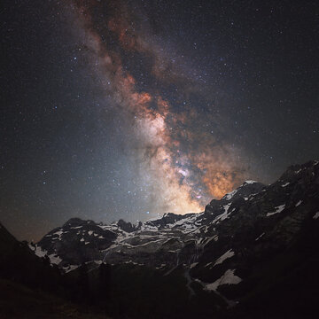 Starry sky and the Milky Way over a mountain range.