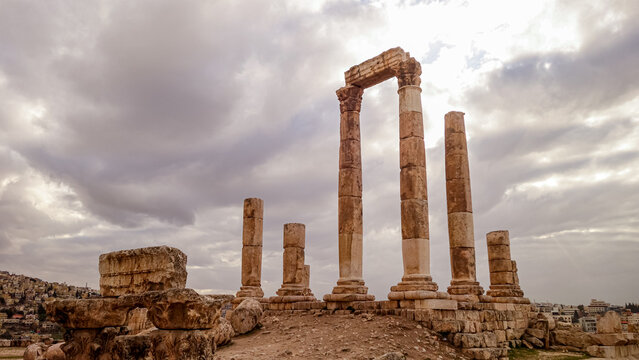 View of the ancient Roman columns of the Temple of Artemis standing against a cloudy sky in the archaeological site of Jerash, Jerash Governorate, Jordan.