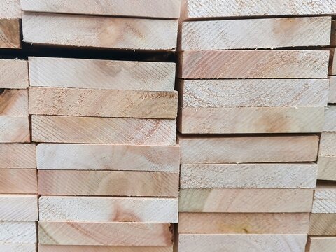 View of neatly stacked wooden planks in a timber yard, showcasing natural wood grain textures and orderly construction materials in Pretoria, Gauteng, South Africa.