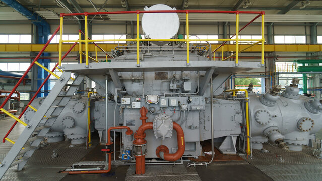 View of industrial machinery with complex piping and metal platform in Latvia.