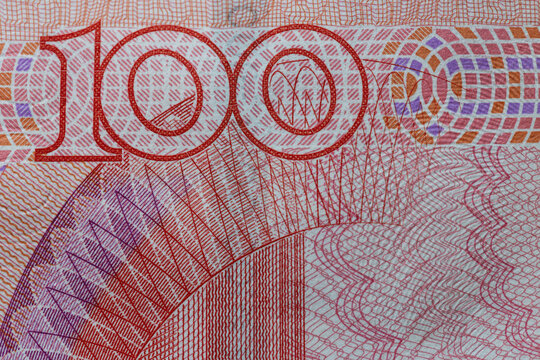 Macro close up of 100 denomination number with security guilloche pattern on Chinese yuan banknote