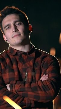 Portrait of handsome man looking at camera among the flying sparks at night
