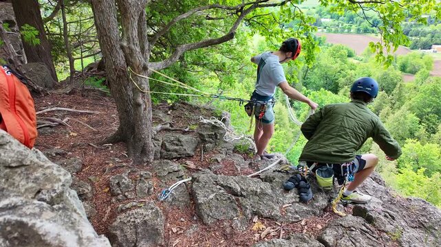Two male climbers setting up ropes and equipment on a cliff's edge at Rattlesnake Point