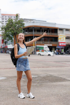 Female traveling in the cities in Chiang Mai Young woman backpacker traveler holding a map and pointing direction while exploring streets of Chiang Mai, Thailand