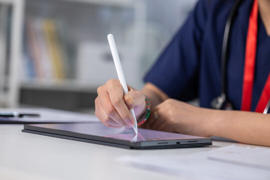 Medical professional using stylus digital tablet desk, creating precise notes during clinical work with focused attention and modern technology