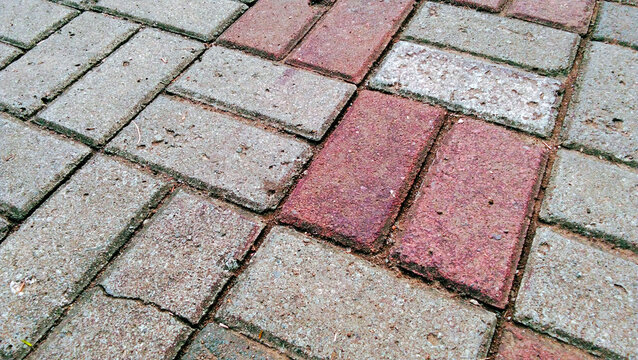 Close-up photo of the texture of red and gray concrete paving blocks.
