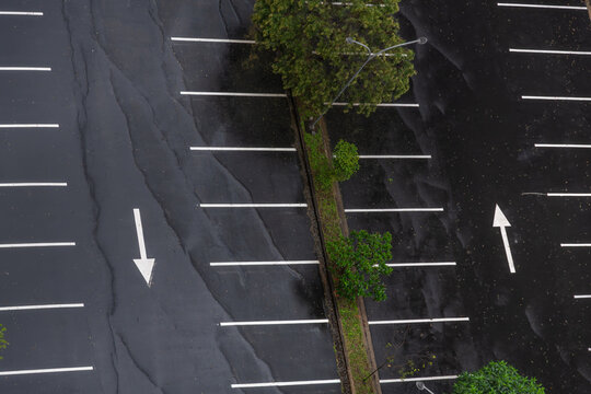 Aerial View of Parking Lot Spaces and Directional Arrow on Wet Surface