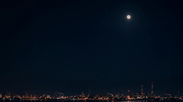 月が見える夜の工業地帯と水辺