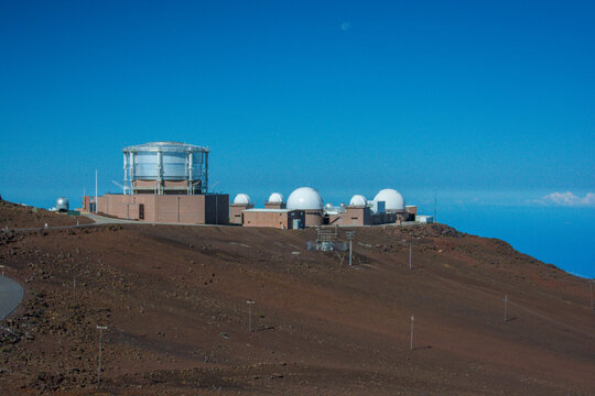View of the Haleakala Observatory domes situated on the volcanic terrain of Maui County, Hawaii, United States.