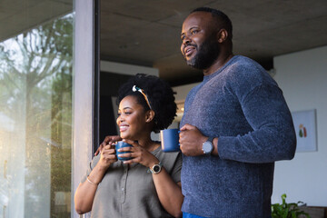 Fototapeta premium African couple standing at home near glass door holding blue ceramic mugs wearing headband