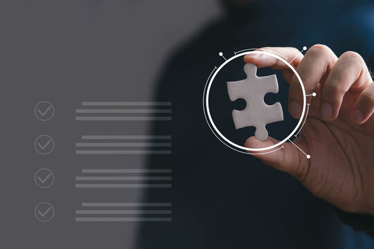 Business solution concept showing a hand holding a puzzle piece with digital interface graphics, representing strategy, problem solving, innovation, teamwork, planning, technology, and growth.