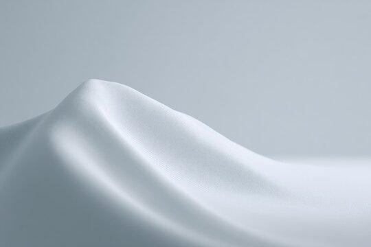 A white satin fabric on a gray background. the fabric has a smooth glossy texture and is a pristine white color. the background is a solid gray color providing a stark contrast to the white fabric.