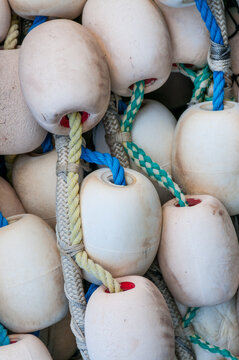 View of fishing net floats with colorful ropes and weathered plastic buoys in Canada.