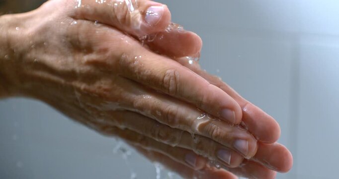 Hands being washed under flowing water in slow motion, creating a cinematic image of cleansing, renewal and letting go. Natural droplets and movement evoke purity, care and emotional relief.