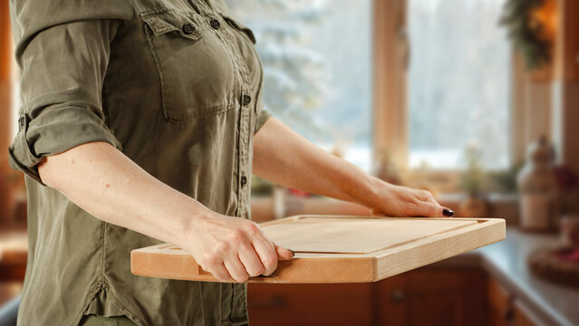 Woman holding wooden tray with copy space &ndash; cozy winter interior concept.