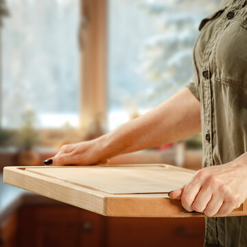 Woman holding wooden tray with copy space &ndash; cozy winter interior concept.