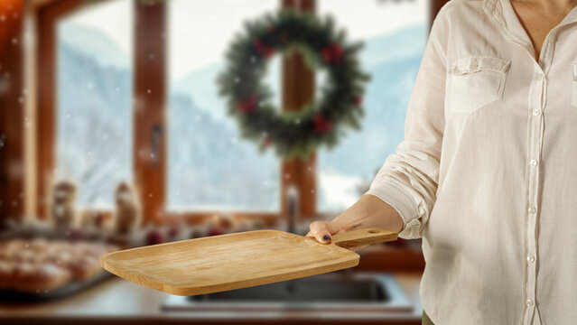 Woman holding wooden tray with copy space &ndash; cozy winter interior concept.