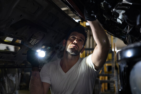 Caucasian mechanic is inspecting the diesel truck engine after annual check up in the professional garage and maintenance all the filter and gear for safety driving concept
