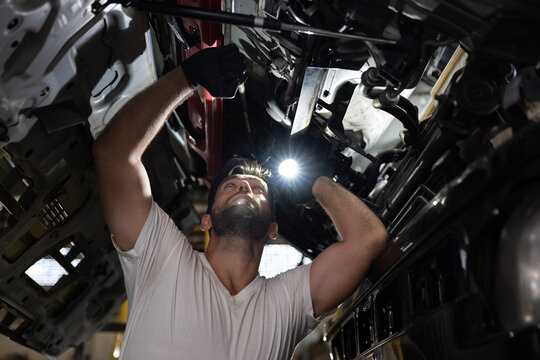 Caucasian mechanic is inspecting the diesel truck engine after annual check up in the professional garage and maintenance all the filter and gear for safety driving concept