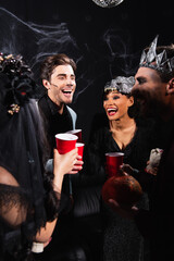 Obraz premium Multicultural friends joyfully celebrate Halloween at a spooky party