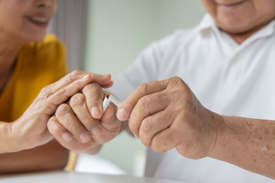 senior southeast asian couple at home, wife asking husband to quit smoking cigarette, and husband successfully make the quit smoking or stop smoking decision, hand closeup shot