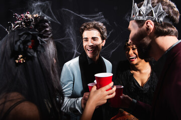 Obraz premium Multicultural friends celebrate Halloween with costumes and laughter
