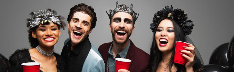 Obraz premium Multicultural friends enjoying a lively Halloween costume party together, banner 