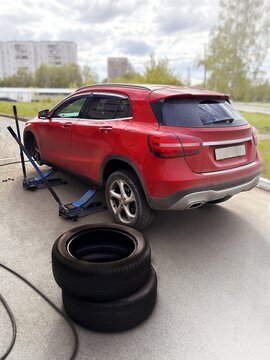 Tire fitting on the street. The red crossover is changed from winter tires to summer tires. Vertical