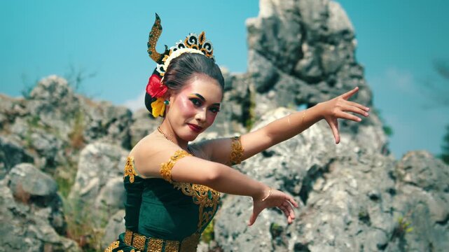 A close look at an Indonesian dancer performing intricate traditional hand gestures (mudras) accompanied by a gentle smile.