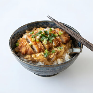 Japanese katsudon rice bowl with crispy golden breaded tonkatsu pork cutlet simmered in savory broth with egg and onions served with chopsticks on rustic bowl isolated on clean white background