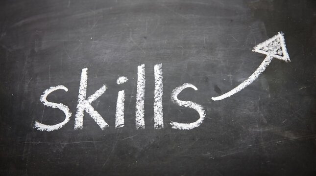 Skills word written in white chalk on a black blackboard with an
