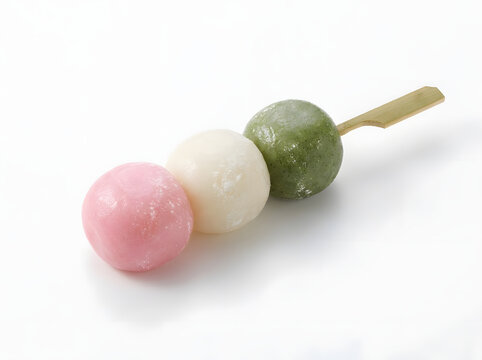 Single skewer of traditional Japanese tricolor hanami dango mochi balls in pink white and green shades on flat bamboo stick isolated against clean white background for wagashi dessert menu