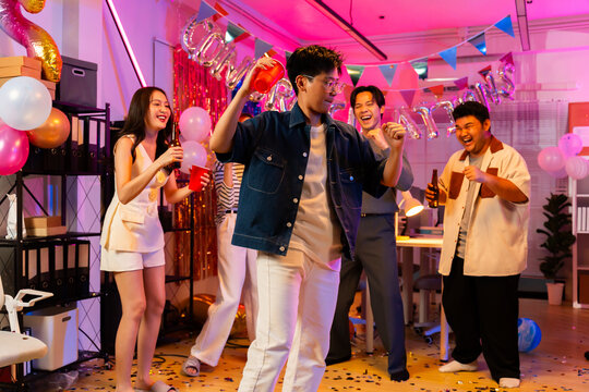 Happy Asian office team celebrating sales target achievement with joyful expressions,business success party in coworking space,Happy asian team celebrating success business achievement among confetti.