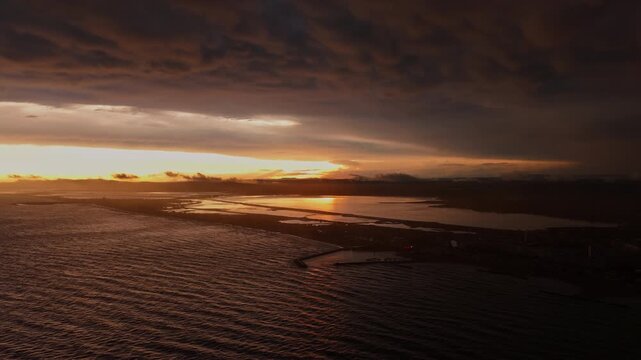 Aerial Mediterranean sunset reflecting on Carnon lagoon and coast