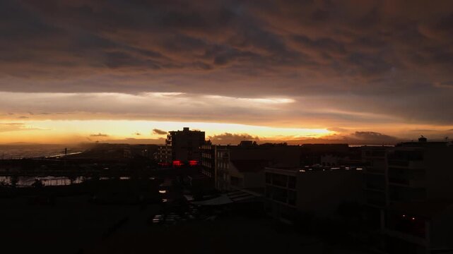 Dark storm clouds over rooftop apartments at Carnon sunset