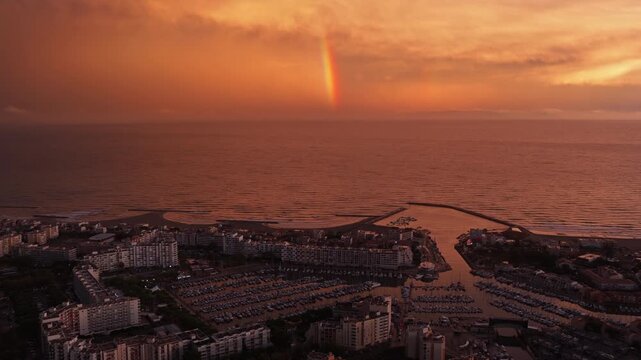 Aerial Carnon marina and beach with sunset rainbow offshore