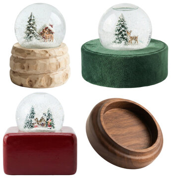 A collection of assorted empty snow globe bases in various materials, finishes, and shapes for seasonal craft projects.